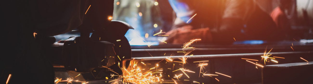 Worker polishes a metal surface with a grinder